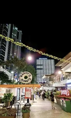 a city at night with people walking down a sidewalk at 2BR at the FORT BGC near Malls, Restaurants & Shops in Manila