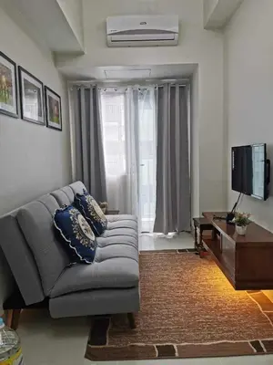 a living room with a couch and a television at Moa SHORE 3 TOWER 2 RESIDENCE in Manila