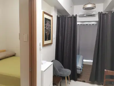 a room with a bed and a chair and a window at Moa SHORE 3 TOWER 2 RESIDENCE in Manila