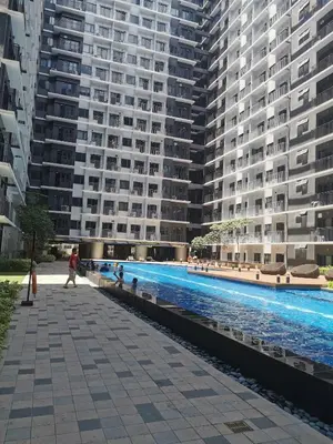 a large apartment building with a large swimming pool at Shore 3 residence Moa Pasay in Manila