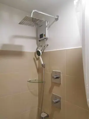 a shower with a glass shower head in a bathroom at Shore 3 residence Moa Pasay in Manila