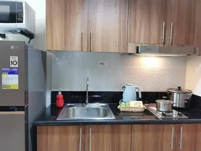 a kitchen counter with a sink and a microwave at Shore 3 residence Moa Pasay in Manila