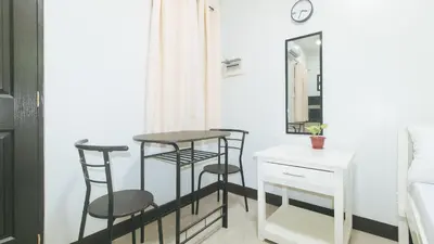 a small room with two stools and a table and a mirror at RedDoorz at MGP Apartelle Near Espana in Manila