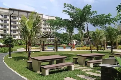 a park with benches in front of a building at Coastal Inspired 2BR Condo I Fast Wi-Fi I Near BGC in Manila