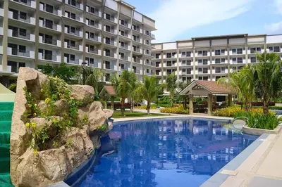 a swimming pool in front of a large building at Coastal Inspired 2BR Condo I Fast Wi-Fi I Near BGC in Manila