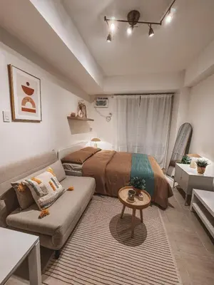 a bedroom with a bed and a couch at Mayas Home in Pasig Aesthetic and Cozy with Pool access and Netflix in Manila