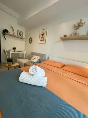 a bedroom with two beds and a living room at Mayas Home in Pasig Aesthetic and Cozy with Pool access and Netflix in Manila