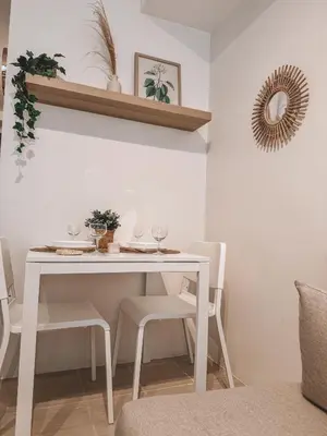 a white dining room table with white chairs and a mirror at Mayas Home in Pasig Aesthetic and Cozy with Pool access and Netflix in Manila