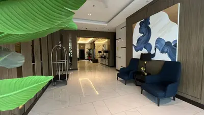 a lobby with two chairs and a large painting on the wall at UrbanEase Living at Charm Residences Near Sta Lucia Mall and Robinsons Mall in Manila