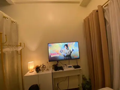 a television sitting on a table in a room at La Mari 1 bedroom at Prisma Residences in Manila