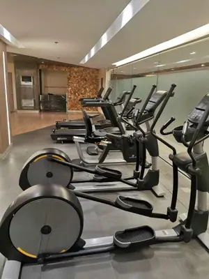 a gym with rows of exercise bikes and treadmills at Mall of Asia Pasay Shore 3 tower condotel in Manila