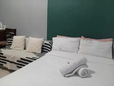 a white bed with towels on top of it at Manila Condotel near US Embassy in Manila