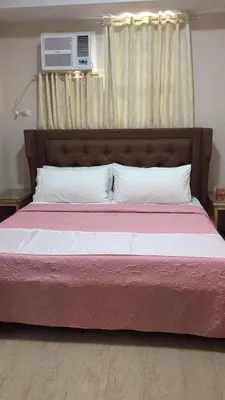 a bedroom with a large bed with a red and white blanket at 101 Newport Boulevard in Manila
