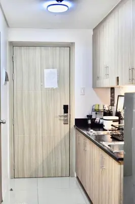 a kitchen with a door in the middle of a kitchen at 1 BR Condo with Balcony in Manila