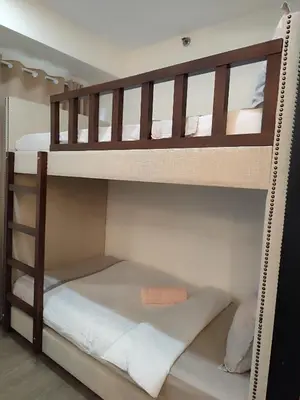 two bunk beds in a room with a bed at Aya's Place Two Bedrooms near MOA in Manila