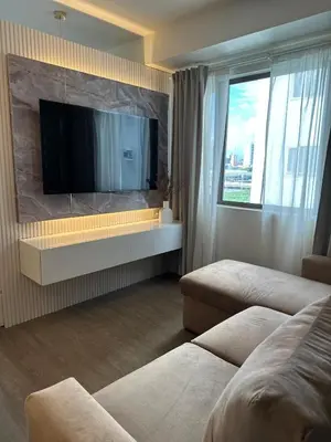 a living room with a flat screen tv on a wall at Aya's Place Two Bedrooms near MOA in Manila