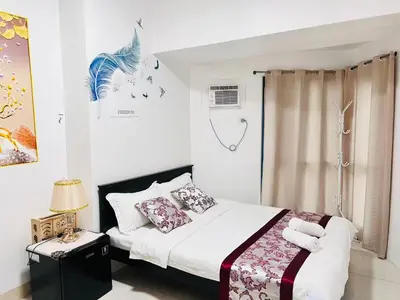 a bedroom with a bed with white sheets and pillows at \u65e5\u843d\u6d77\u6e7e\u516c\u9986 in Manila