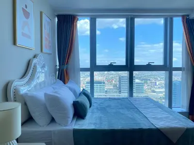 a bedroom with a bed with a large window at BGC Skyline 2BR Suite with Parking in Uptown BGC in Manila