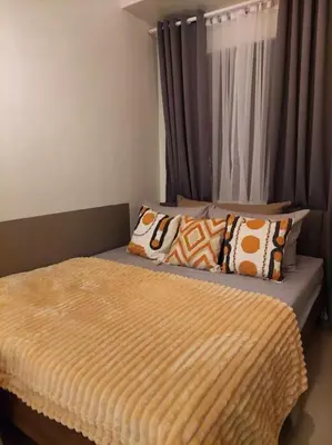 a bedroom with a bed with pillows on it at 1014 - Cavite Minimalist Condo with Resort-like Amenities & Hi Speed Wifi in Dasmariñas