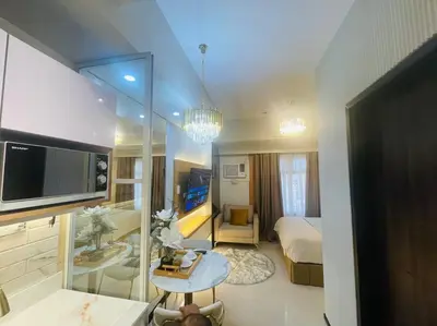 a hotel room with a bed and a television in a room at Marias Suite near Manila bay FREE use of Pool in Manila