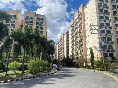 a street with tall buildings and a person on a motorcycle at WNSuites in Manila