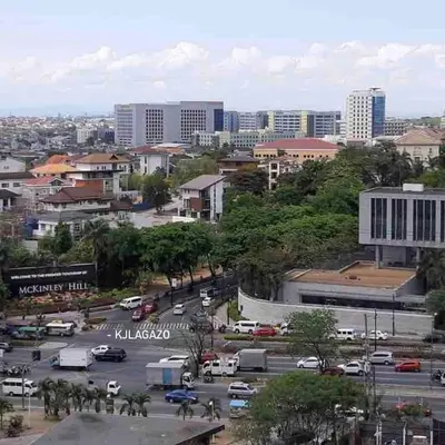 a city with a parking lot with cars and buildings at Budget-friendly Condo Near Bgc, Venice #rt34008 in Manila