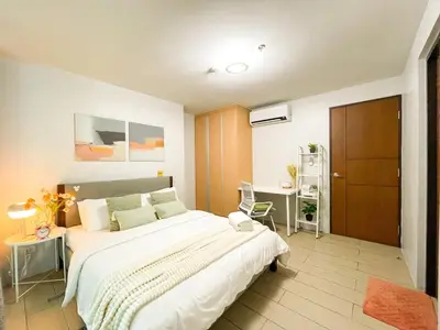 a bedroom with a large bed and a desk at Prime BGC Condo at Uptown Area #oursw11g in Manila