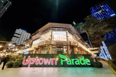 a downtown paradise sign in front of a building at night at Prime BGC Condo at Uptown Area #oursw11g in Manila