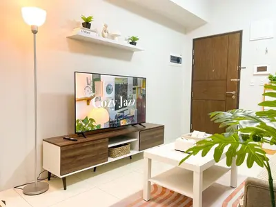 a living room with a flat screen tv on a wooden entertainment center at Prime BGC Condo at Uptown Area #oursw11g in Manila