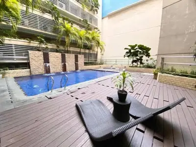 a patio with a chair with a potted plant next to a pool at 1Bedroom Accommodation Near Airport in Manila