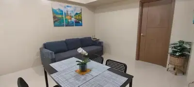 a living room with a table and a blue couch at 1Bedroom Accommodation Near Airport in Manila