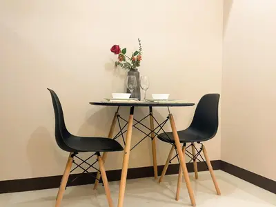 a table with two chairs and a vase with flowers at BGC Condo Facing Mitsukoshi Mall #upt122g in Manila