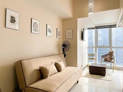 a living room with a couch and a large window at Chic BGC Condo Near Uptown Parade #upt124r in Manila