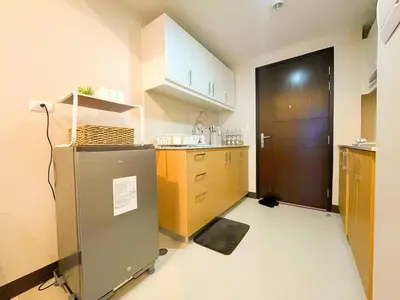 a kitchen with a refrigerator and a brown door at Luxurious Modern BGC Condo at Uptown #upt131h in Manila