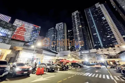 a city street with cars parked in front of tall buildings at Luxurious Modern BGC Condo at Uptown #upt131h in Manila