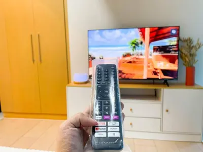 a person holding a remote control in front of a tv at Luxurious Modern BGC Condo at Uptown #upt131h in Manila