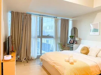 a bedroom with a large bed and a large window at Luxurious Modern BGC Condo at Uptown #upt131h in Manila