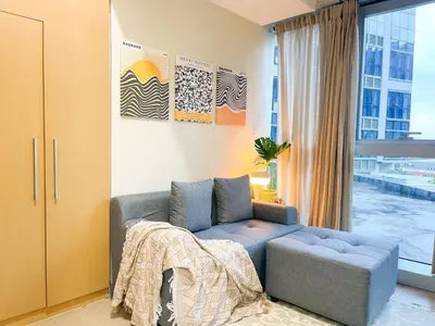 a living room with a blue couch and a window at Prime BGC 1BR Near Mitsukoshi Mall #upt16m in Manila