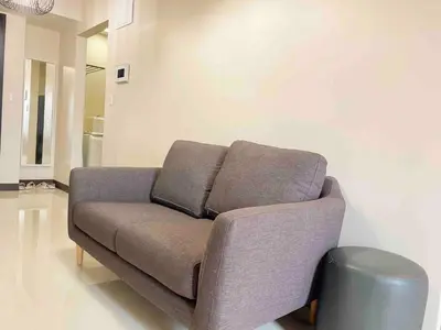 a couch in a living room with a trash can at Exclusive BGC Condo at Uptown Area #upt136d in Manila