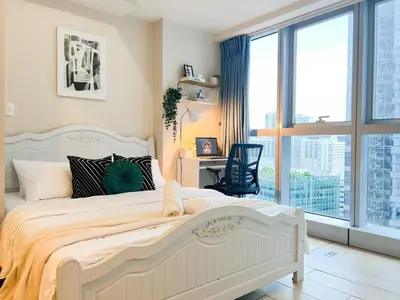 a bedroom with a white bed and a large window at Upscale BGC Stay Near Mitsukoshi #upt130g in Manila
