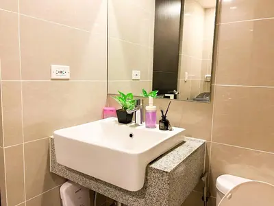 a bathroom with a white sink and a mirror at Upscale BGC Stay Near Mitsukoshi #upt130g in Manila