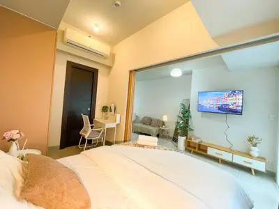 a bedroom with a large white bed with a large window at Elegant BGC Condo Across Mitsukoshi Mall #upt27p in Manila
