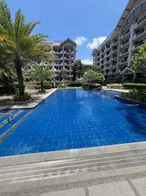 a large blue swimming pool in front of a building at 2-bedroom with Balcony in a Resort Setting - H Ivory in Manila