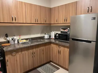 a kitchen with a stainless steel refrigerator and a microwave at 2-bedroom with Balcony in a Resort Setting - H Ivory in Manila