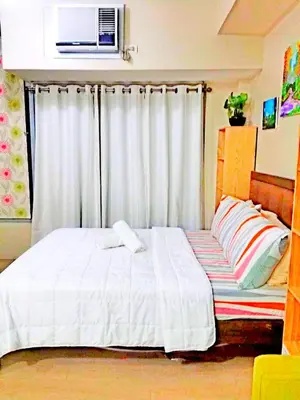 a bedroom with a white bed and a window at Eastwood Legrand Tower 3 condominium in Manila