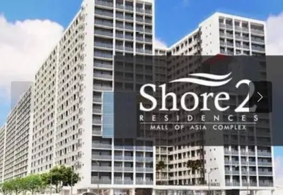 a large white building with a sign on it at Georgia Luxe Suite at Shore 2 MOA in Manila