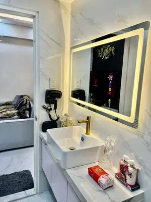 a white bathroom with a sink and a mirror at Gina Staycation Condo Unit in Manila