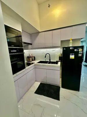 a kitchen with a black refrigerator and a sink at Gina Staycation Condo Unit in Manila
