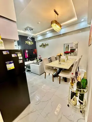 a dining room and living room with a table at Gina Staycation Condo Unit in Manila