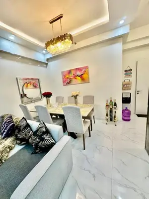 a dining room with a couch and a table at Gina Staycation The Atherton DMCI Parañaque in Manila